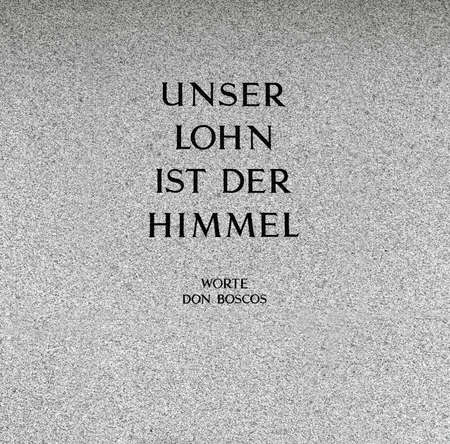 "our reward is heaven". saying of don bosco on a grave stone in a cemeteryの写真素材