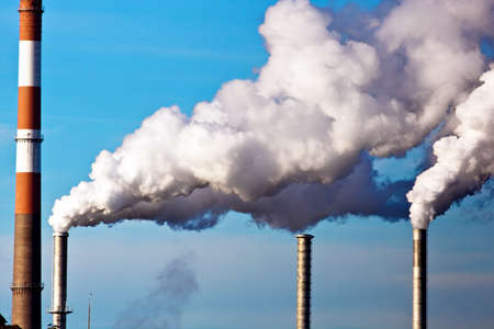 the smoking chimneys of a factory against blue sky. for chimneys rising white smoke onの写真素材