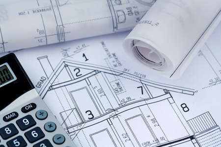a blueprint of an architect with a calculator. symbolic photo for financing and planning of a new house.の写真素材