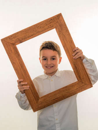 a child holds a frame in her hand and looks through.の写真素材