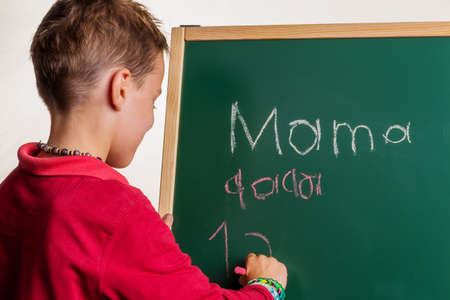 one child writes the word "mom" on a blackboardの写真素材