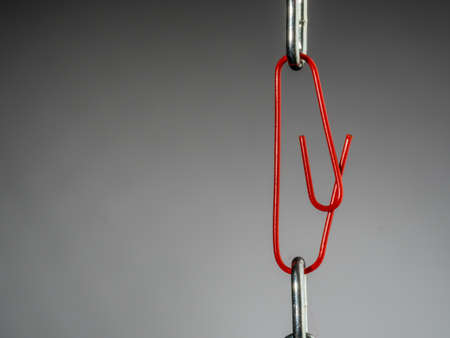 a chain is held together with a b?rokklammer. symbol photo for security, trust and teamworkの写真素材