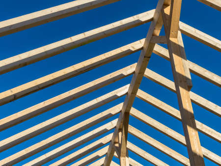 in a house with a new roof is being built on a construction site. carrier wooden roof truss.の写真素材