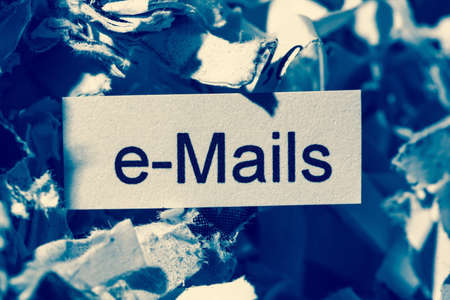 papierschnitzel tagged with e-mails, symbol photo for data destruction, mails and data flooding