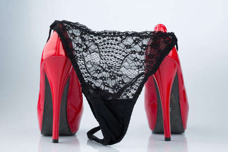 red high heels and a black slip, symbol photo for erotic and fetishの写真素材