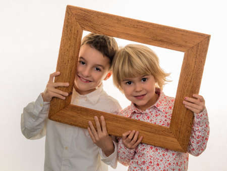 a child holds a frame in her hand and looks through.の写真素材
