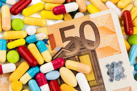 euro notes and tablets, symbol photo for costs of drugs and health insurance.の写真素材