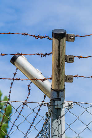 a site is secured by a fence with barbed wireの写真素材