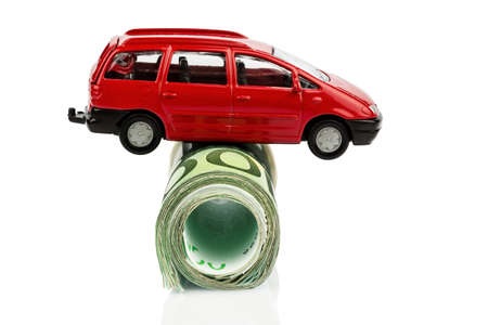 a car standing on euro bills. costs for the purchase of automobiles, gasoline, insurance and other car costsの写真素材