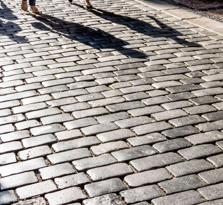 shadows of people on a pavement