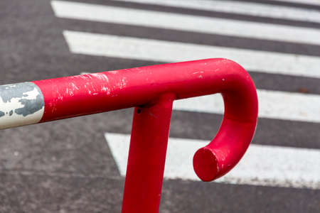red railing against crosswalkの写真素材