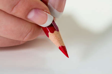hand with red pencilの写真素材