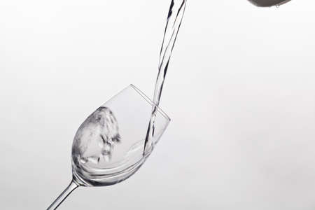 water is poured into a glass of waterの写真素材