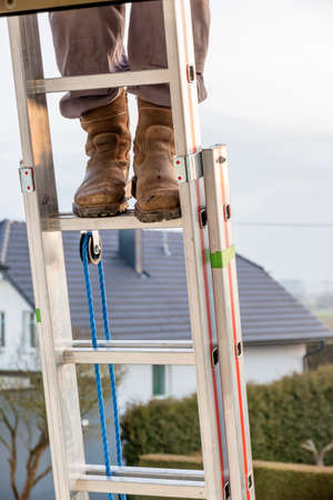 craftsman on a ladder at the houseの写真素材