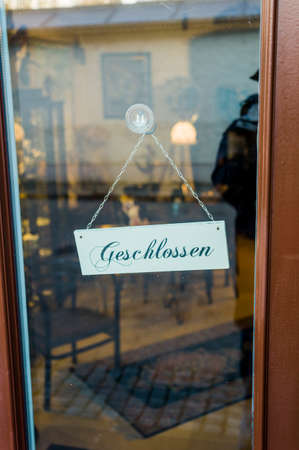in a door to a shop a sign hangs closedの写真素材