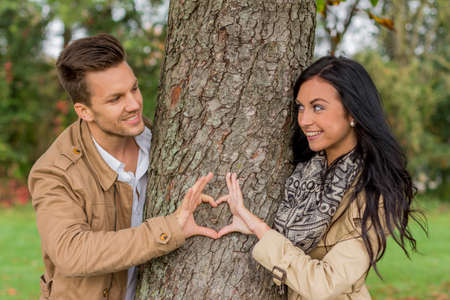 couple in love behind a treeの写真素材