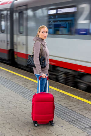 woman is waiting for train on railway stationの写真素材