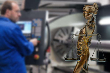 Worker with justitia statue. Symbol for emplyment lawの写真素材