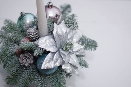 Christmas decoration: fir sprig,candle, cones and berries in snowの写真素材