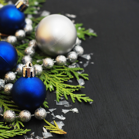 Christmas winter decoration background. Blue globes with silver beads on black background.の写真素材