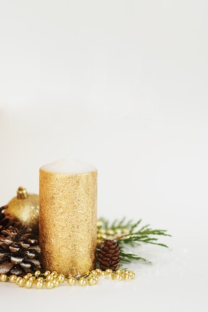 Christmas golden candle with pincones and beads decorationの写真素材