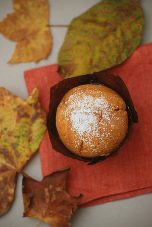 Homemade muffin on orange napkin and autumn leavesの写真素材