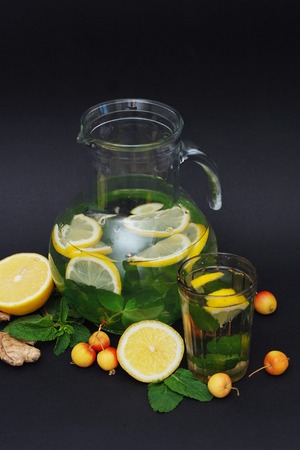 Water detox in a glass jar and a glass. Fresh green mint and berries. A refreshing and healthy drink. Copy space.の写真素材