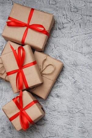 Above brown gift box and red ribbon with tag on wood background with space.の写真素材