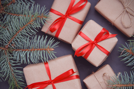 Christmas background composition.Gifts with brown paper craft and red ribbon with fir green branches.の写真素材