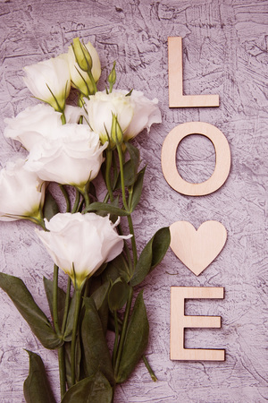 Wooden Letters, and white bouquet on grey wooden background. Romantic holiday concept, top view.の写真素材