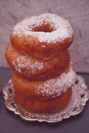 Sweet donuts with sugar powder on wooden plank with pink napkinの写真素材