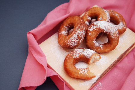 Donuts with powdered sugar and pink napkin, close up. Food photography.の写真素材