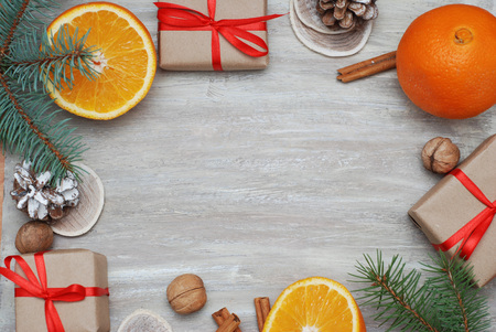 Christmas background with gift boxes, citrus, nuts, pincones, fir branchesの写真素材