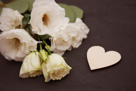 Wooden heart and white flowers on an old wooden board. Backgrounds and textures. St. Valentine's Day.の写真素材