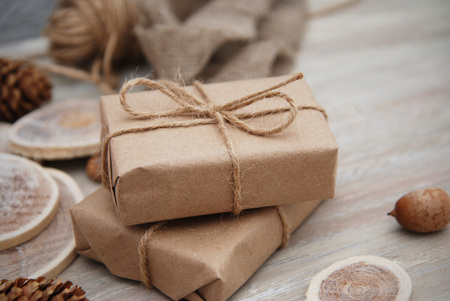 Christmas gift or present box wrapped in kraft paper with Decoration on Rustic Wooden Background.の写真素材
