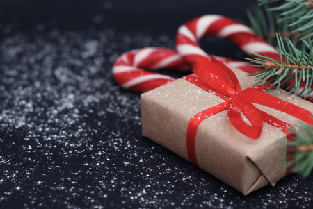 Christmas fir branch, snow texture with snow and red gift boxe on blue board with copy spaceの写真素材