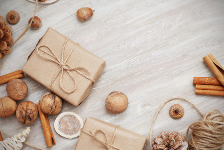 Christmas New Years gift box with red ribbon bow. Tangerines pine cones walnuts fir tree branches. Greeting card template dark background copy space.の写真素材