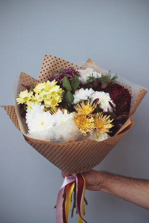 Colorful Beautiful Bouquet of chrysanthemum. A Hand Holding flower bouquet. Autumn flowers. Vertical image.の写真素材