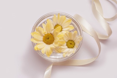 Beautiful spa composition. Bowl with flowers on water and ribbon.の写真素材