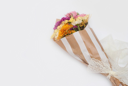 Variety of colorful Chrysanthemums Flowers Wrapped in Brown Paper. Autum narrangement. Gift bouquet.の写真素材
