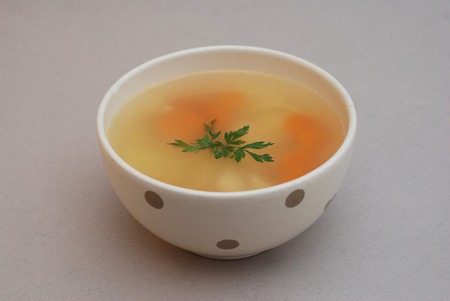 Chicken Soup in bowl isolated on grayの写真素材