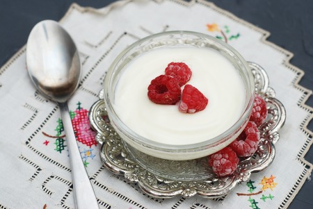 White yogurt with raspberries in glass bowlの写真素材