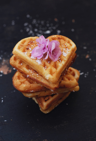Clasic Waffle Heart Shape Dessert on Black Background, isolated. Vertical Image. Food concept.の写真素材