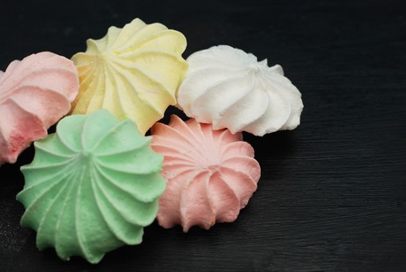 Coloured Meringue on bBack Background. Sweet Dessert with Text Space.の写真素材