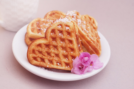 Wafer cakes in the shape of heart lie on a small plate on a served wooden table. Valentines Day Backgroud,の写真素材