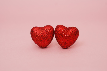 Valentines Day hearts - two Red Hearts, Glitter on Shiny, Sparkle on Pink Backgroundの写真素材