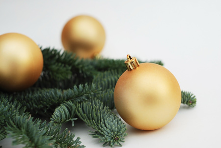 Christmas Background with Copy Space. Golden Cristmas Tree globes or Balls with Fir Branches Isoalted. Festive Greeting card.の写真素材