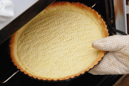 Preparation baking the pie. Mans hands puts form with the batter out of the oven. Cooking Process.の写真素材