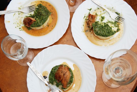 Dinner. Roast chicken breast with Spinach and Mashed Potatoes on Round Table with White Wine Glasess.の写真素材