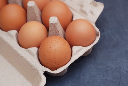 Fresh farm eggs on a wooden rustic background. Dark light.の写真素材